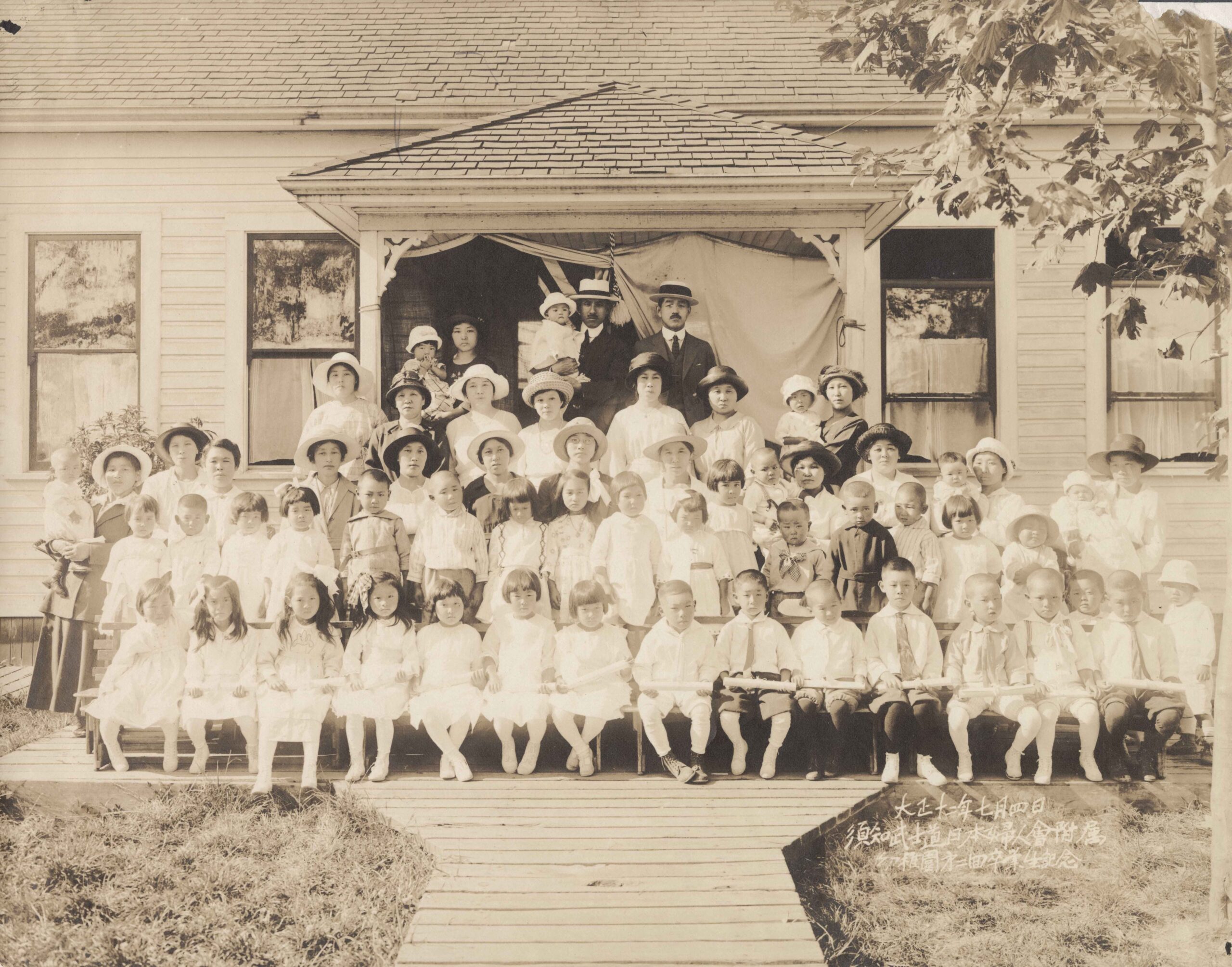 1923 Japanese Canadian kindergarten graduates in Steveston with members of the Fujinkai (women’s association).<br><br><i>Yoshinosuke Yoshioka fonds, item BCCA 2742.195</i>